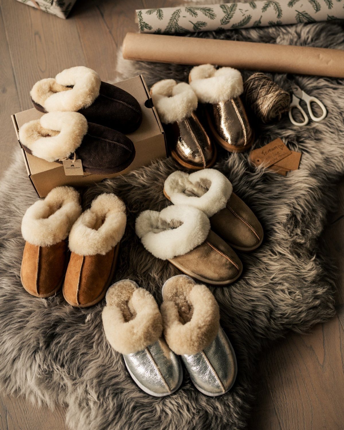 Shearling lined slippers in various metallic and brown colors on a faux-fur rug.