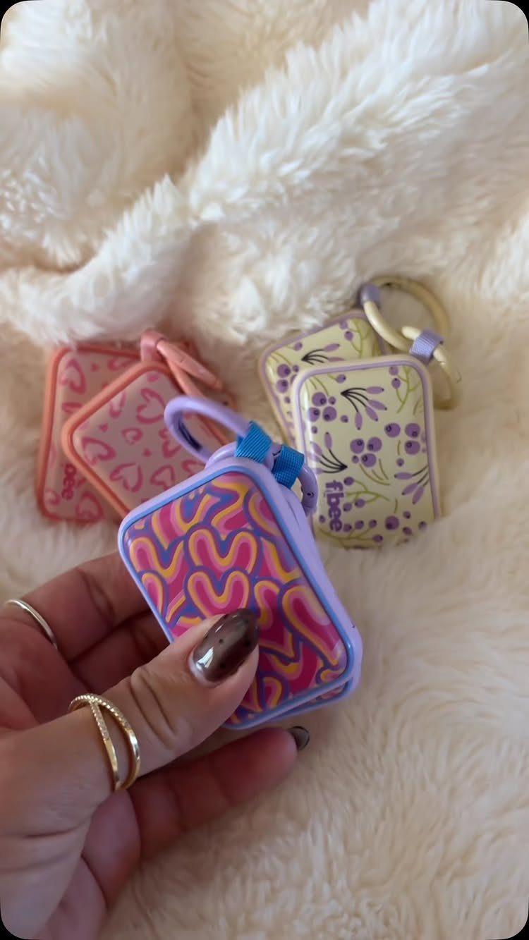 Small patterned pouches in purple, pink, and yellow on white fluffy fur.