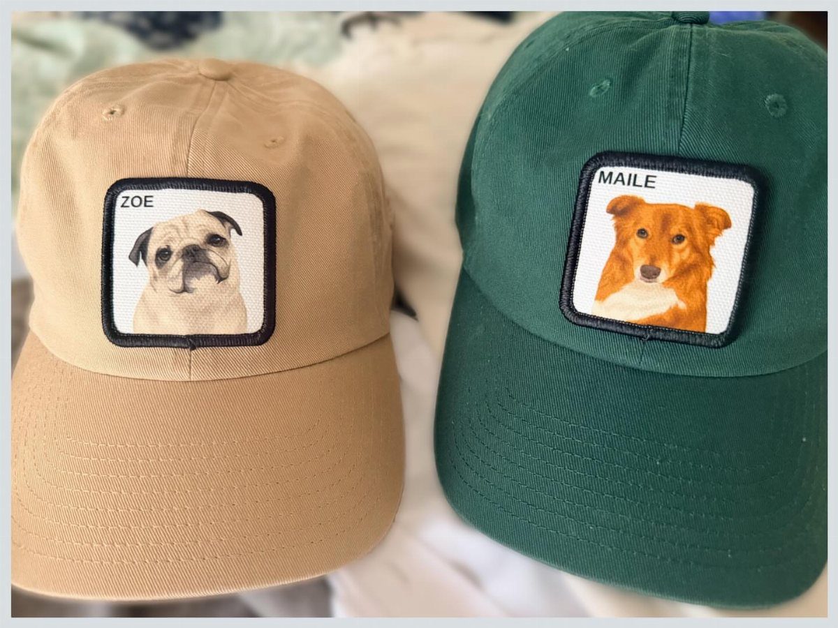 Two baseball caps with custom embroidered pet portraits of dogs and their names.