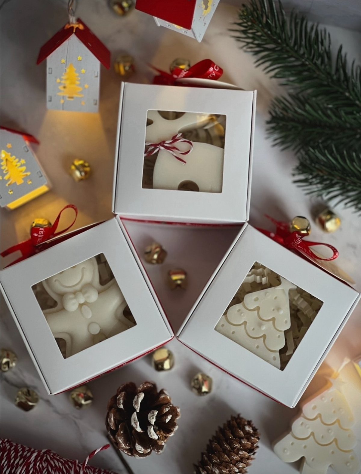 White chocolate Christmas treats in gift boxes with gold bells and pine cones.