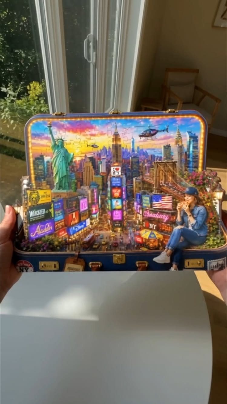 Detailed New York City miniature diorama built inside a blue open suitcase.