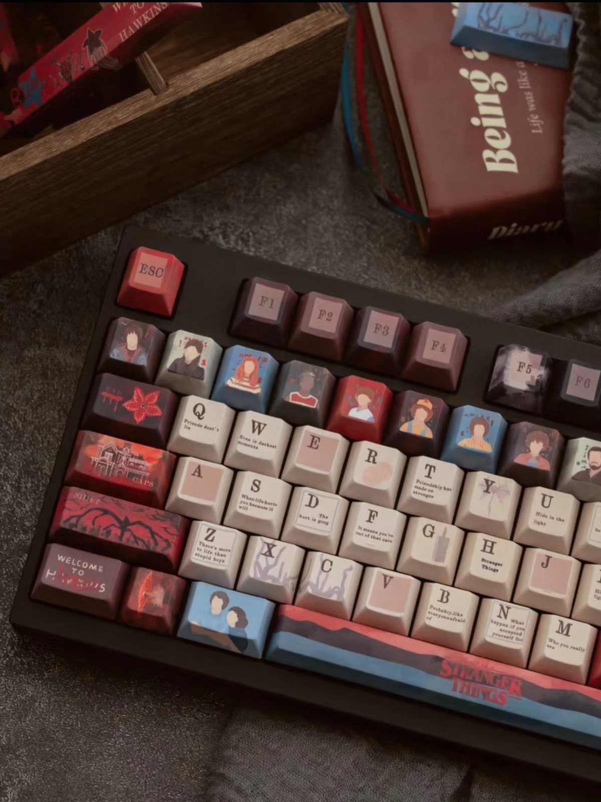 Custom Stranger Things mechanical keyboard with character keycaps and quotes on a desk.