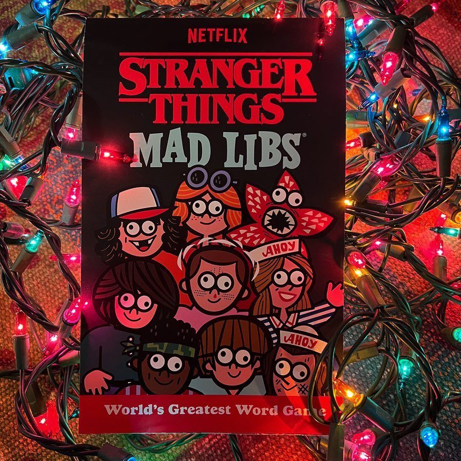 Stranger Things Mad Libs book surrounded by colorful glowing Christmas lights