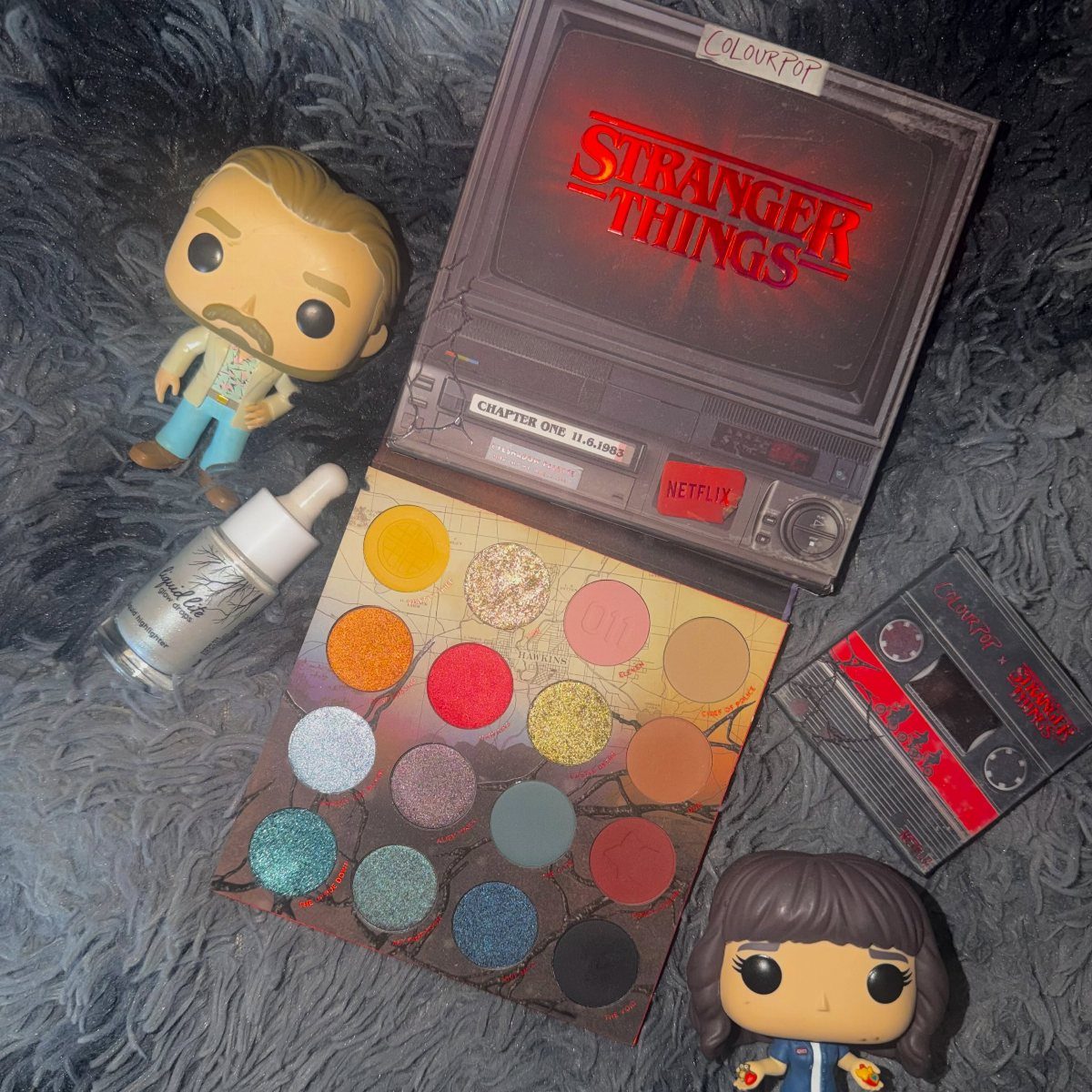 Stranger Things themed eyeshadow palette with Funko Pop figures and a cassette tape.