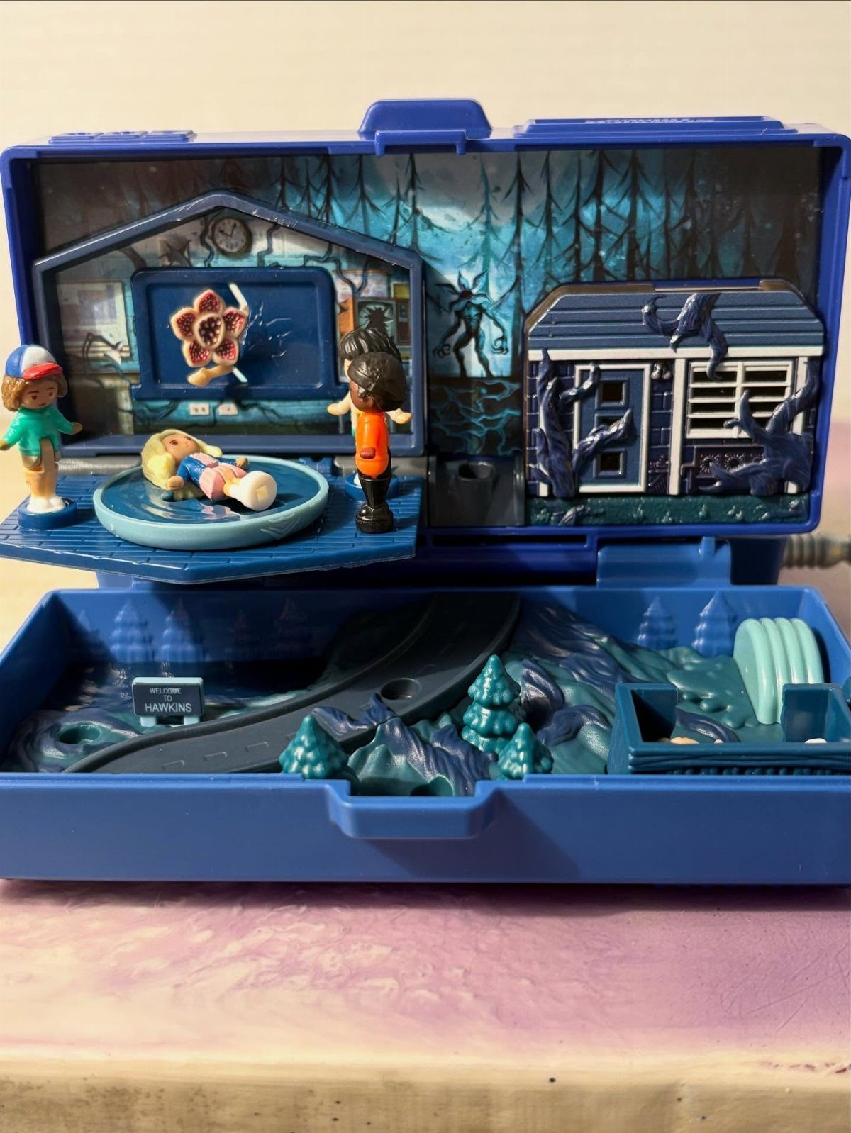 Stranger Things toy playset with figurines and scenes inside a blue plastic case
