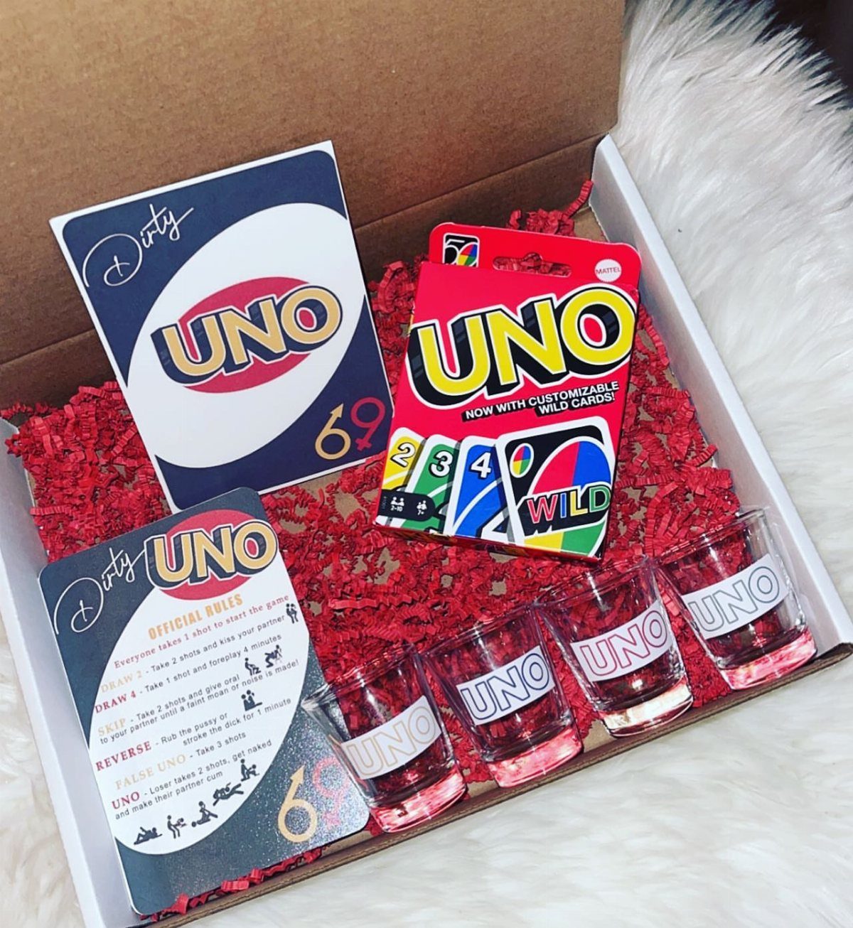 Uno card game and matching shot glasses in a gift box with red filler.