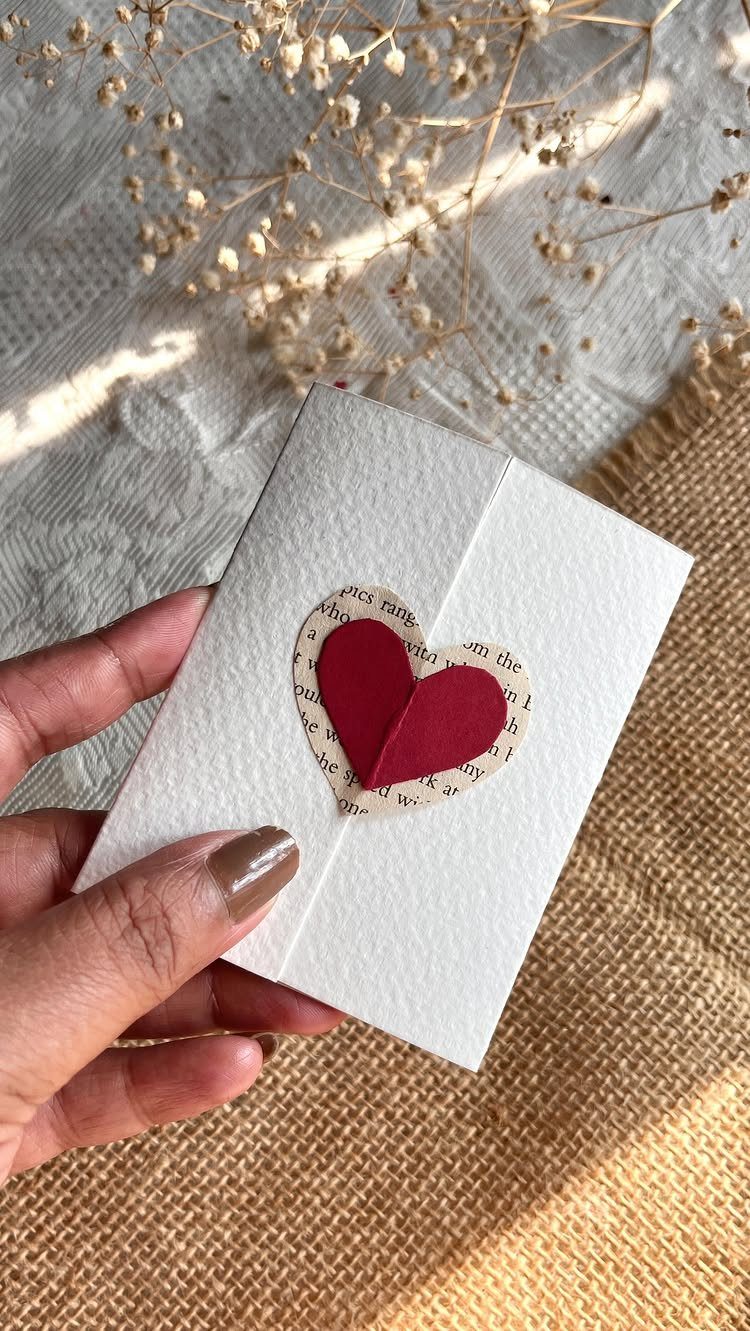 Handmade white card with a red paper heart and newsprint heart detail.