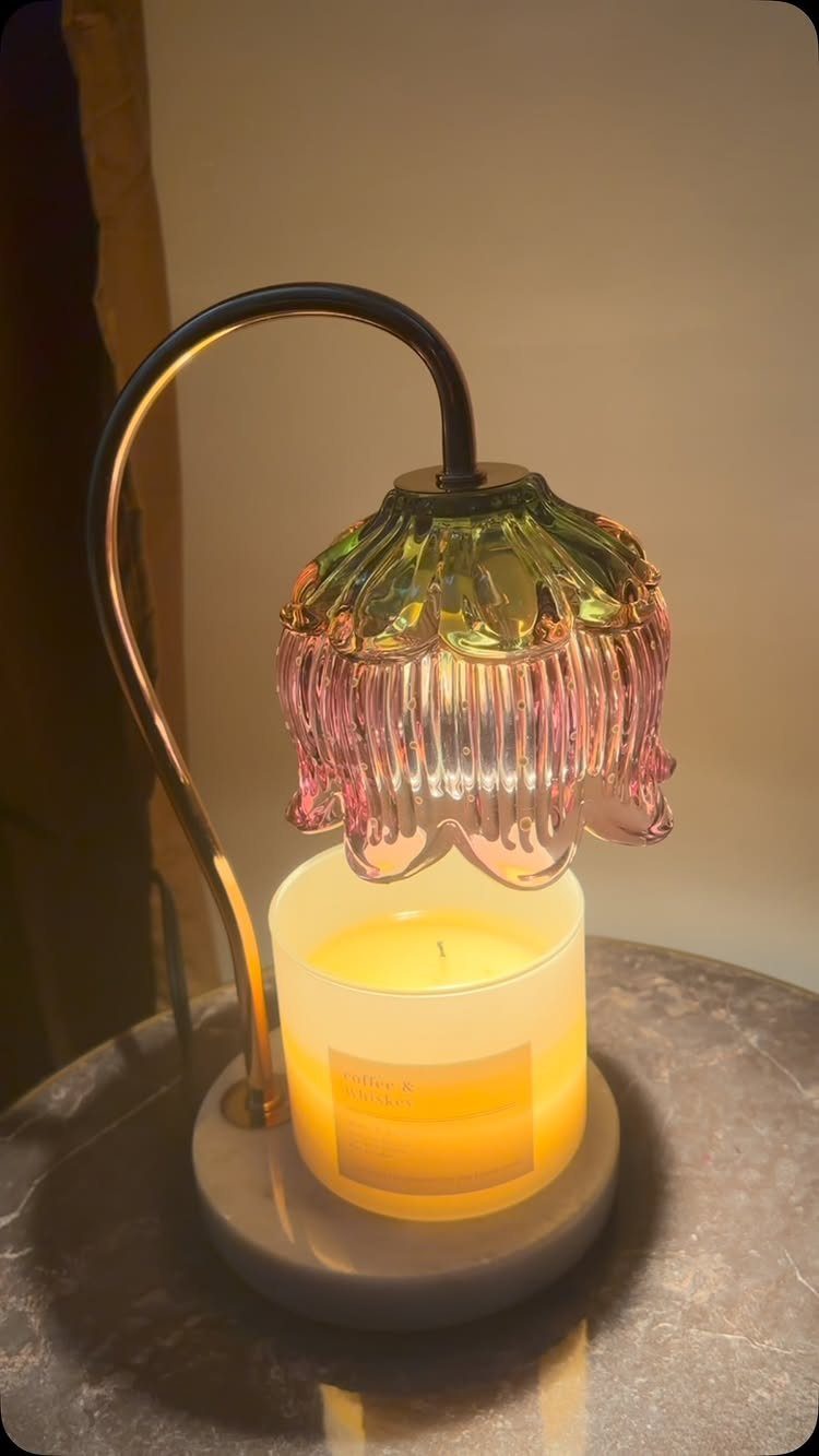 Candle warmer lamp with a colorful flower glass shade heating a jar candle.
