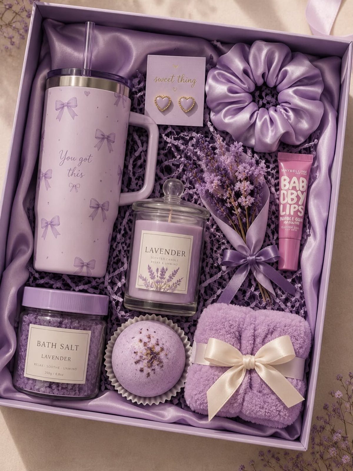 Purple gift box with lavender-scented bath products, a tumbler, and a scrunchie.