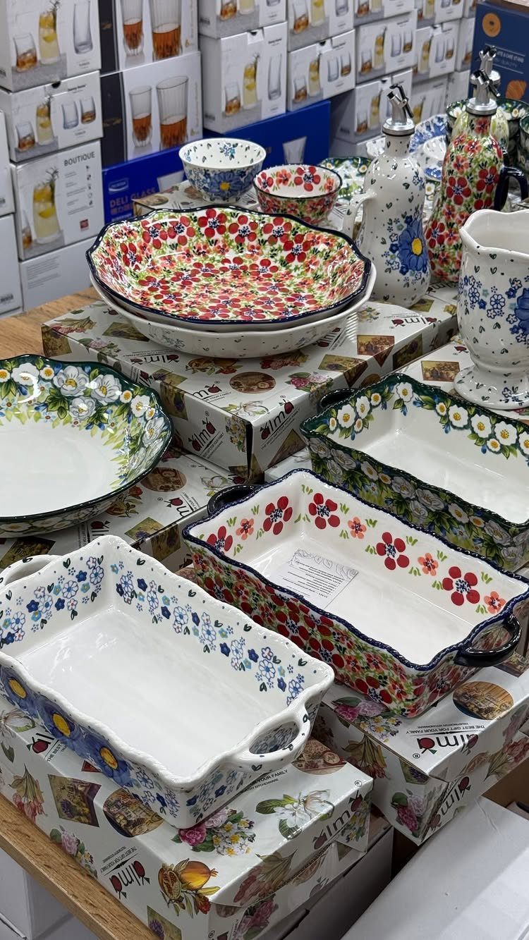 Floral patterned ceramic bowls and baking dishes displayed on decorative gift boxes.