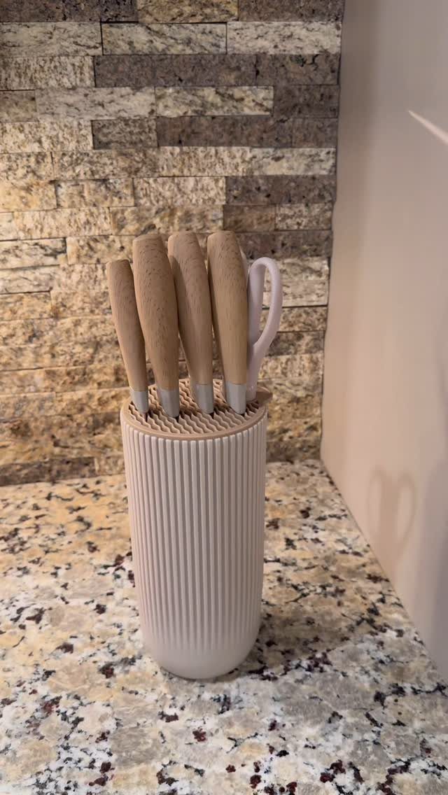 Beige ribbed knife block with wooden handled knives on a granite countertop