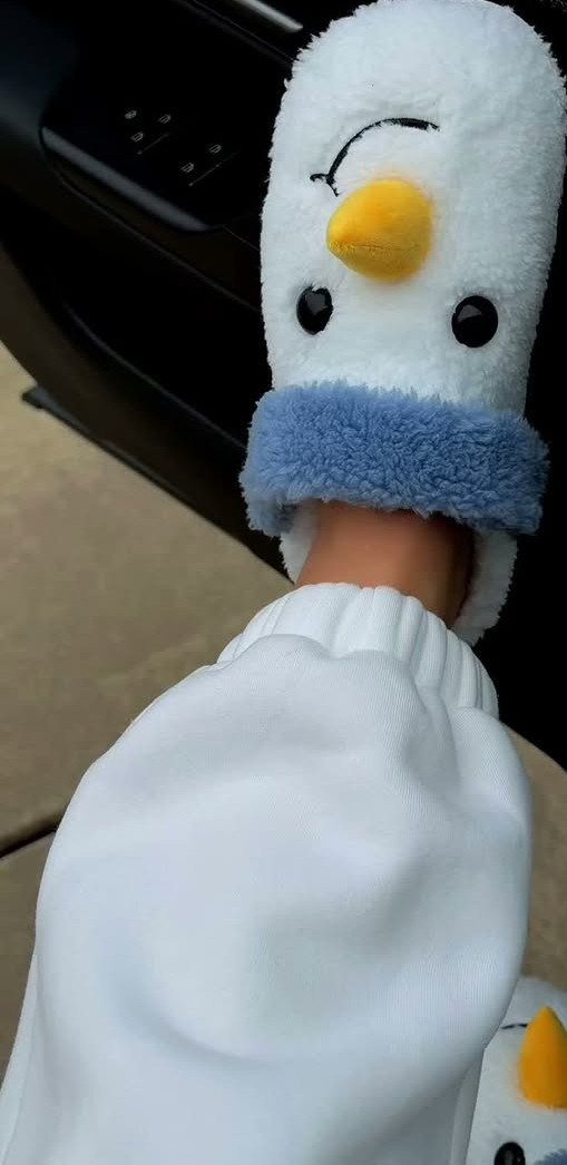 Olaf snowman plush slippers worn on a foot with white sweatpants.