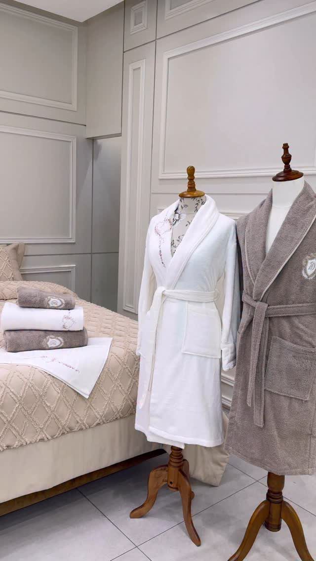 White and taupe plush bathrobes displayed on mannequins in a neutral bedroom