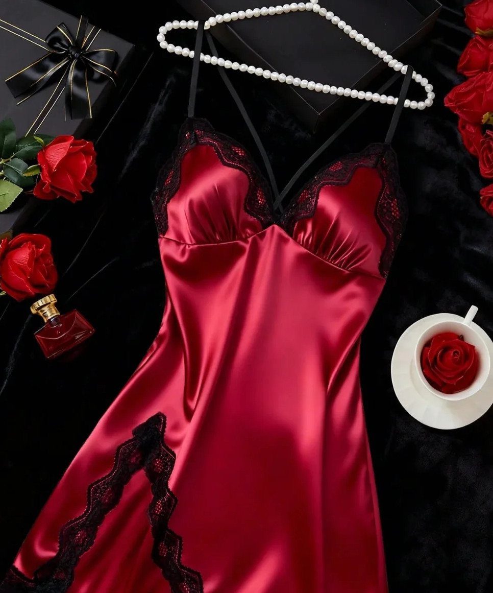 Red satin slip dress with black lace trim surrounded by roses and pearls