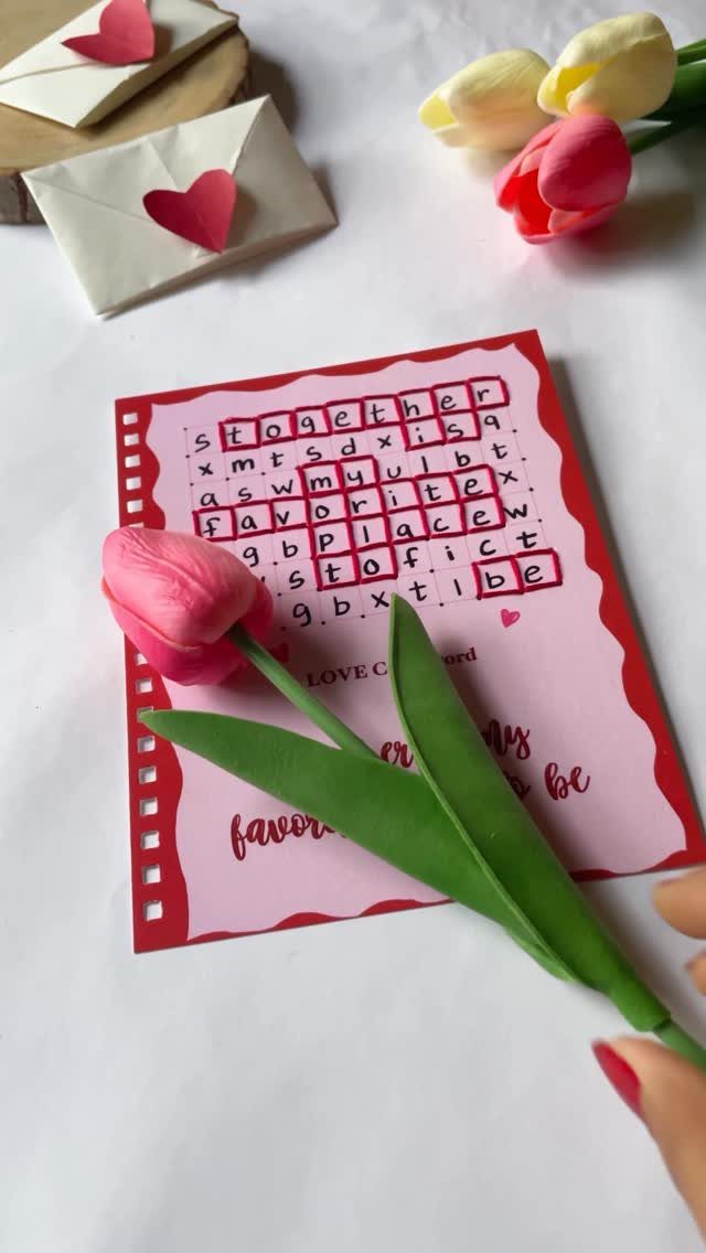 Romantic word search card with a pink tulip and heart-sealed envelopes.