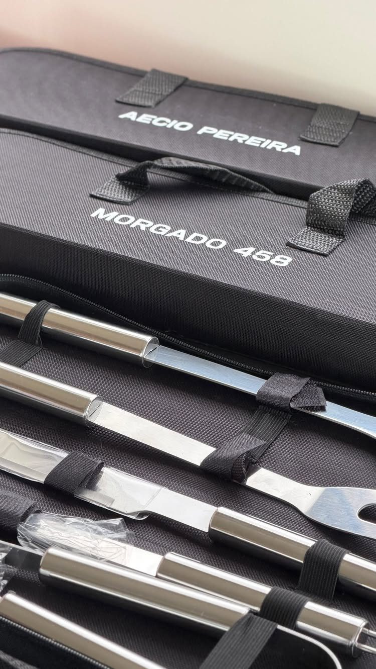 Stainless steel grilling tools in a black carrying case with personalized name labels.