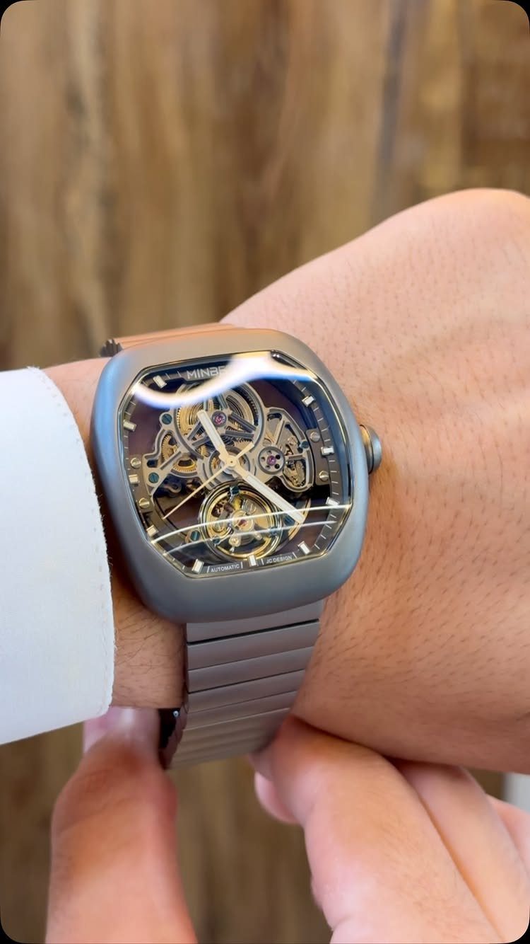 12 Useful Gifts for Men: From Chef's Knives to Multitools 10 Luxury skeleton watch with grey metallic band on a man's wrist