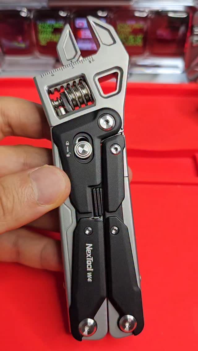 12 Useful Gifts for Men: From Chef's Knives to Multitools 4 Nextool multitool with adjustable wrench held by a hand against red background