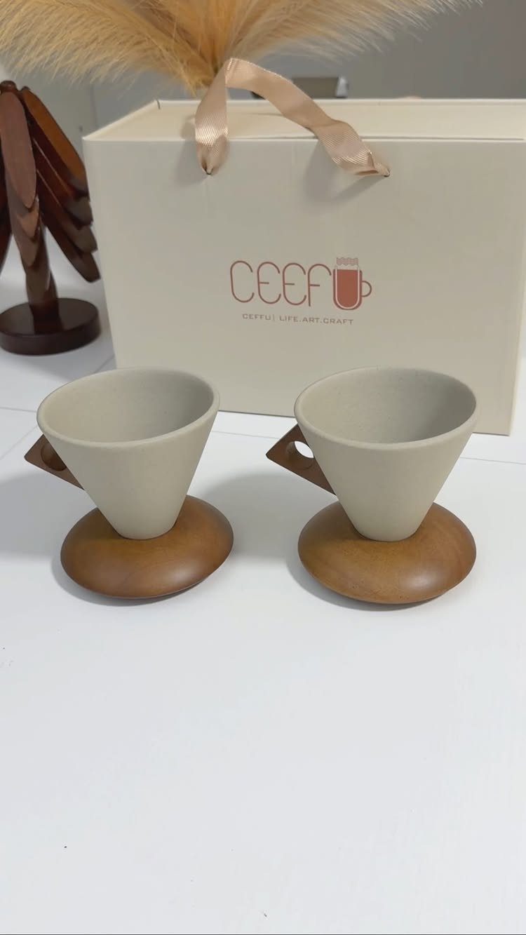 12 Useful Gifts for Men: From Chef's Knives to Multitools 9 Two beige ceramic pour-over coffee drippers with wooden bases and a gift box.