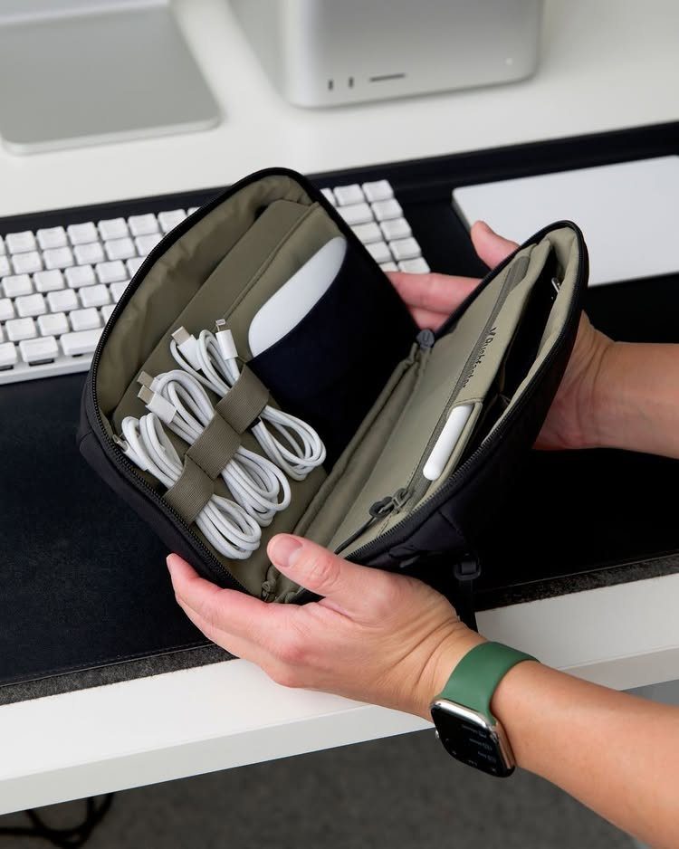 12 Useful Gifts for Men: From Chef's Knives to Multitools 3 Black tech pouch held open showing organized white cables and electronic accessories.