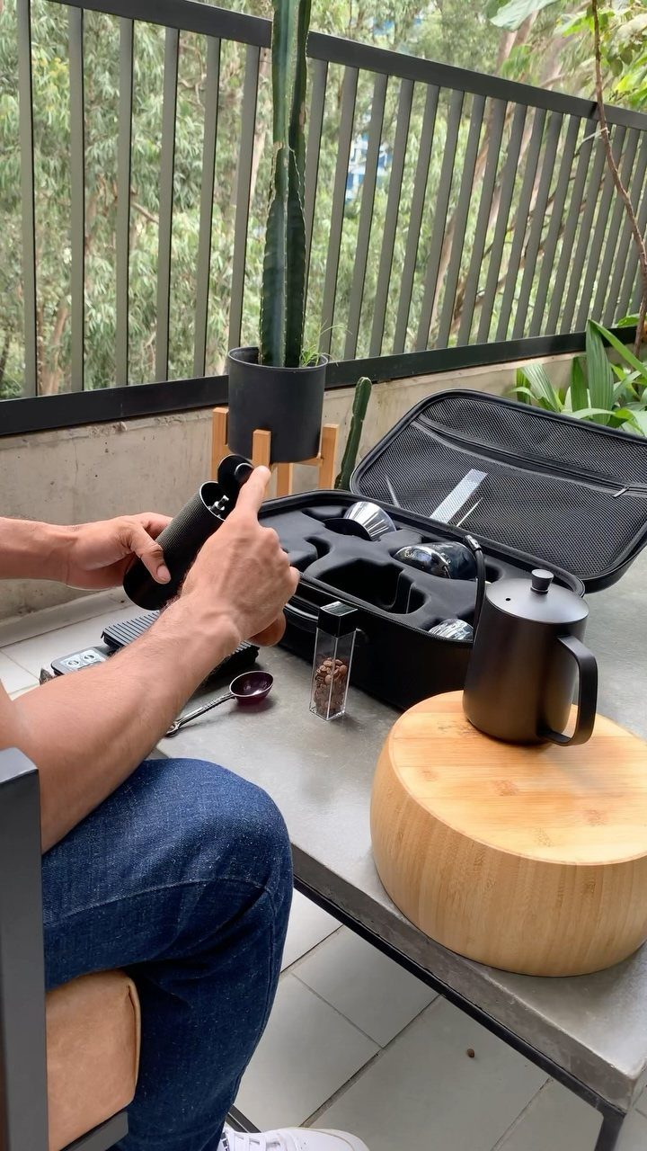 12 Useful Gifts for Men: From Chef's Knives to Multitools 8 Portable coffee brewing kit with black accessories and coffee beans on outdoor table