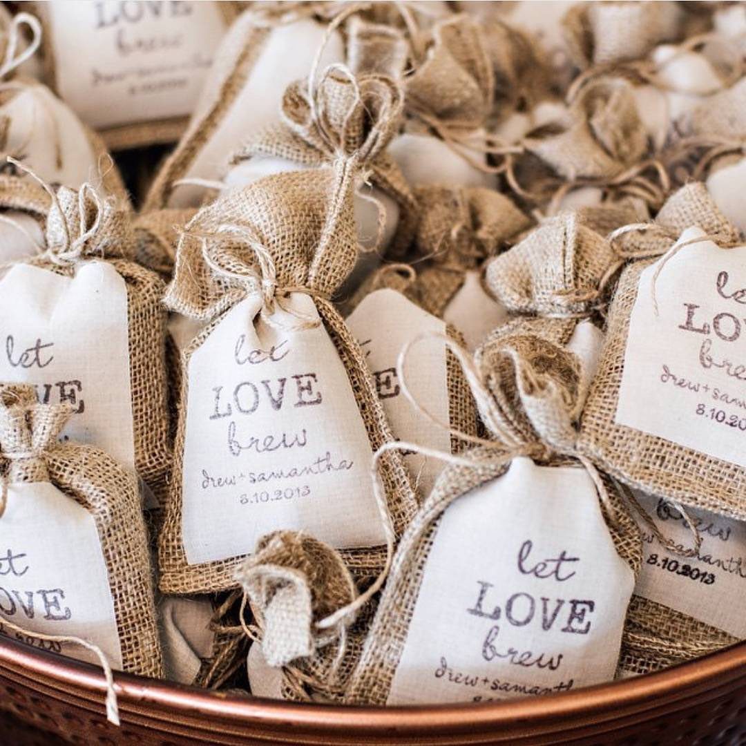 Burlap coffee favor bags with 'let LOVE brew' tags in a copper bowl