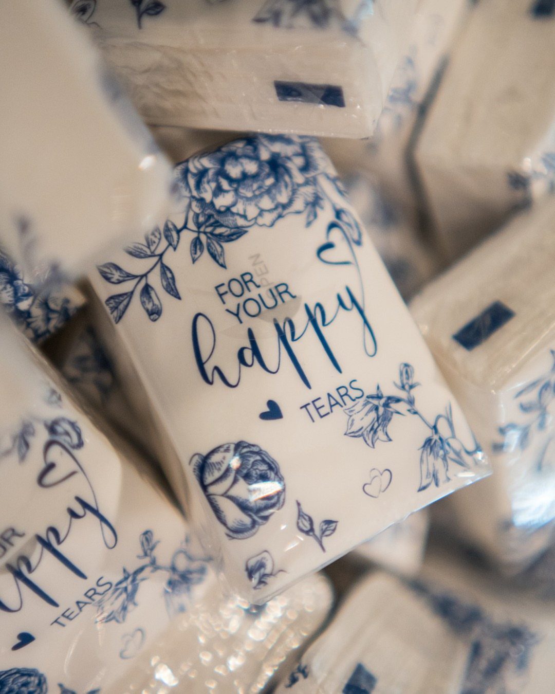 Tissue packets with blue floral designs and text reading For Your Happy Tears.