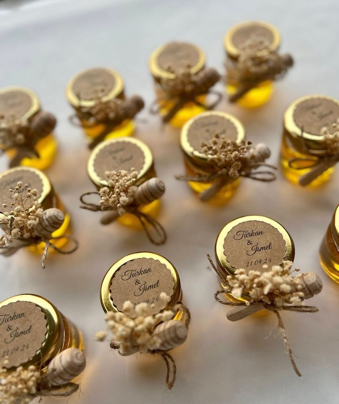 Mini honey jars with gold lids, personalized labels, and tiny wooden honey dippers.