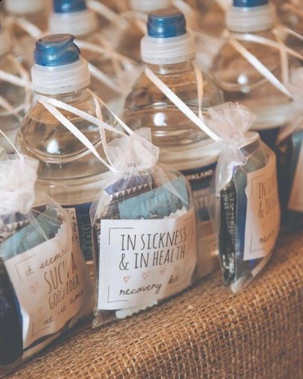 Water bottles and organza bags labeled as recovery kits on a burlap cloth.
