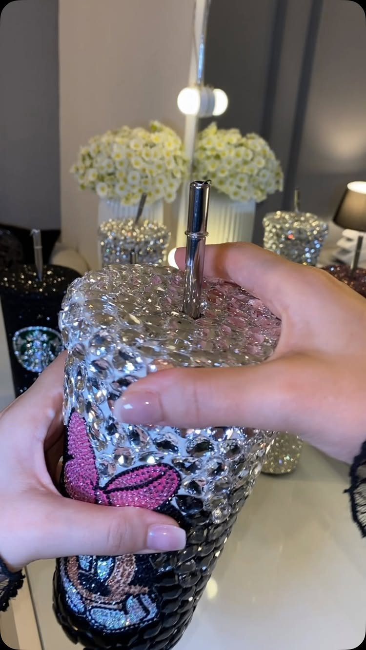 Rhinestone covered tumbler cup with Minnie Mouse design held by two hands