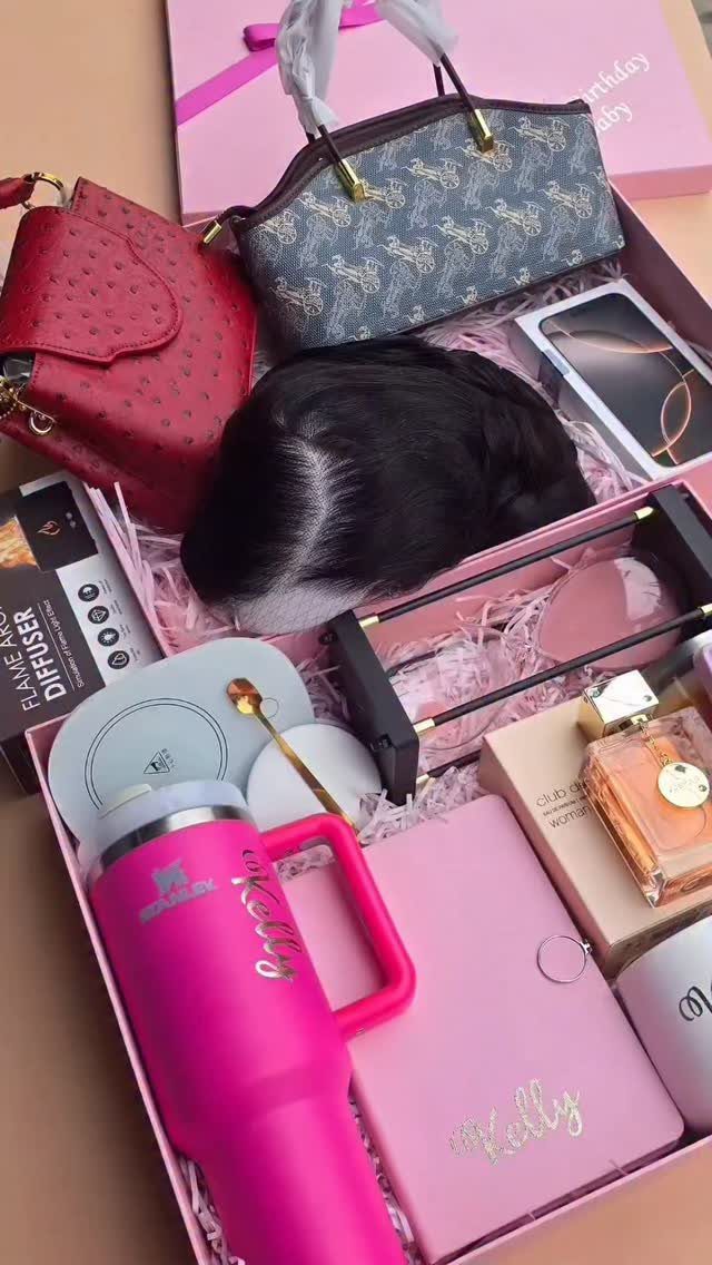 Personalized gift hamper containing handbags, pink tumbler, notebook, and perfume in a box.