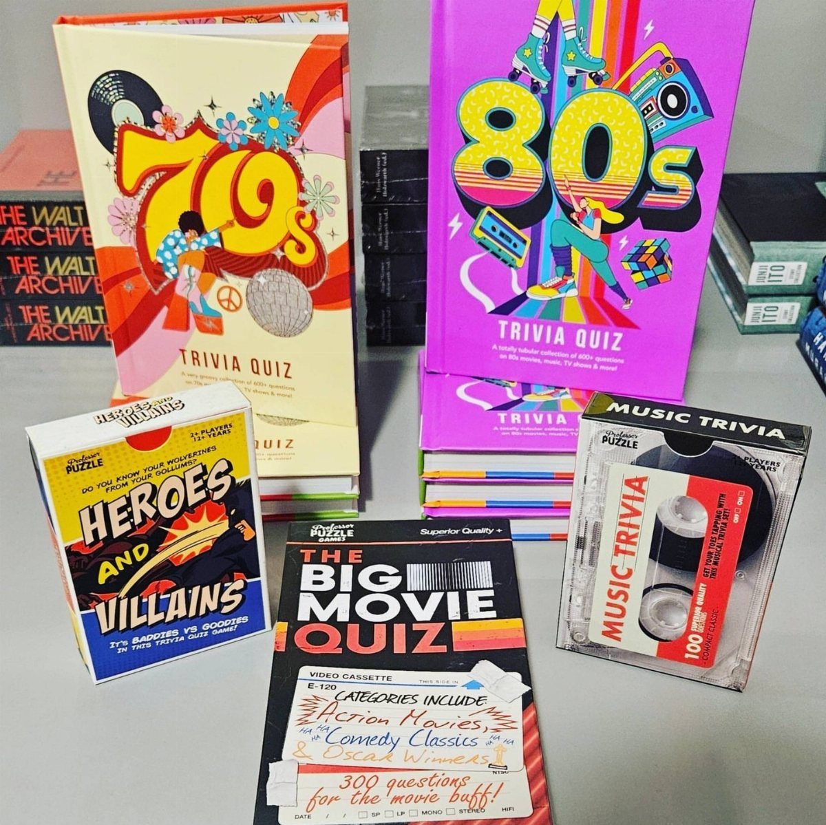 Colorful trivia quiz books and games arranged as gift ideas on a table.