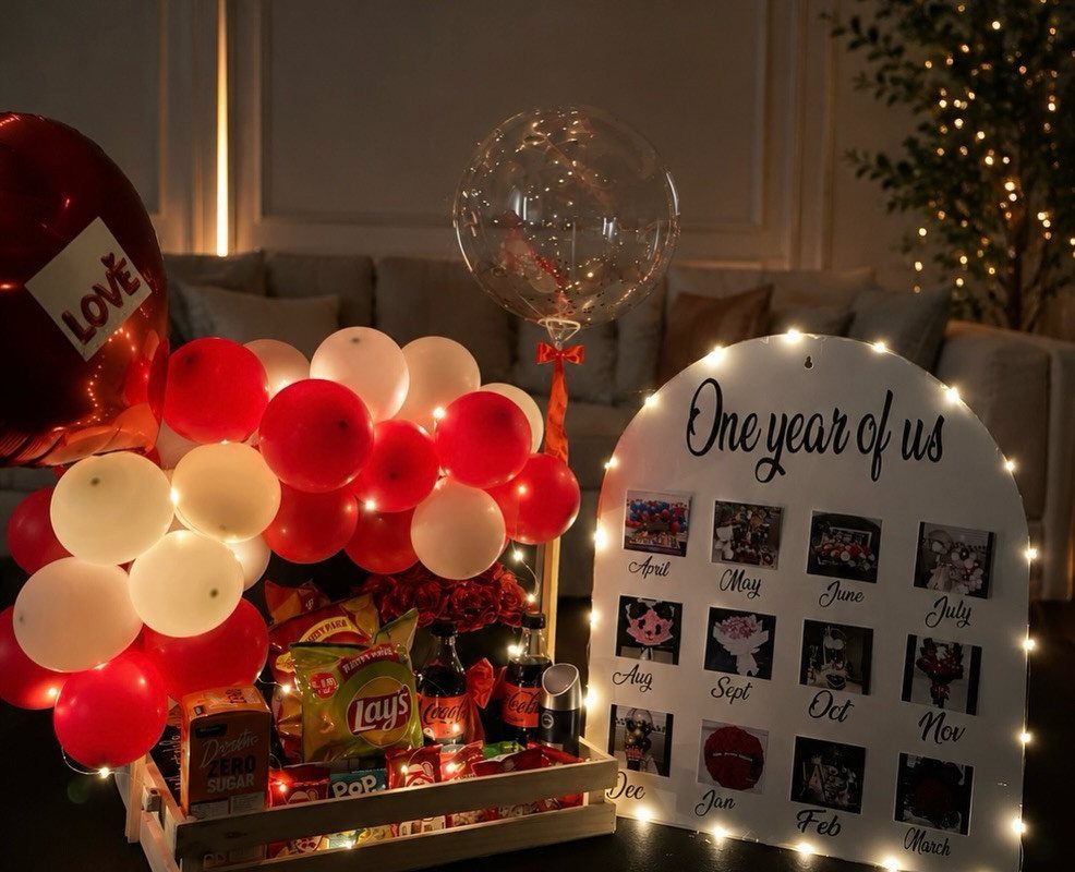 Celebratory gift set with balloons, snacks, and a monthly photo board for anniversary.